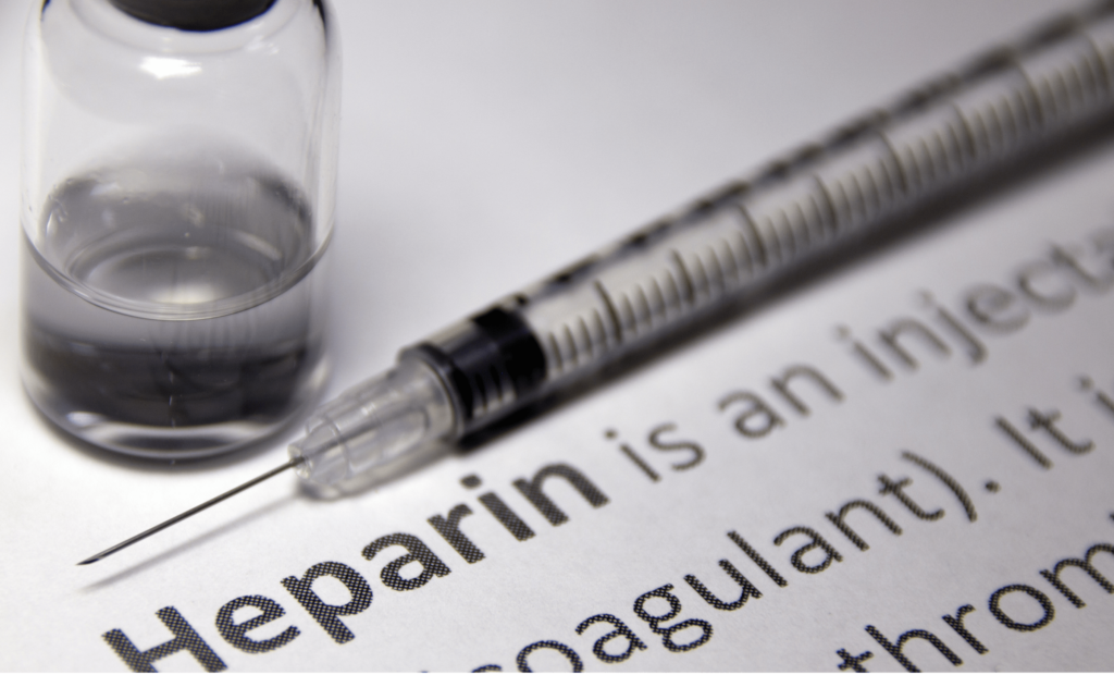 A description of herapin sits underneath a syringe and half-empty vial.
