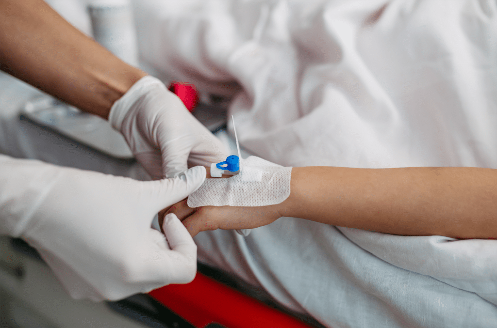 Patient receiving a peripheral intravenous catheter (PIVC).