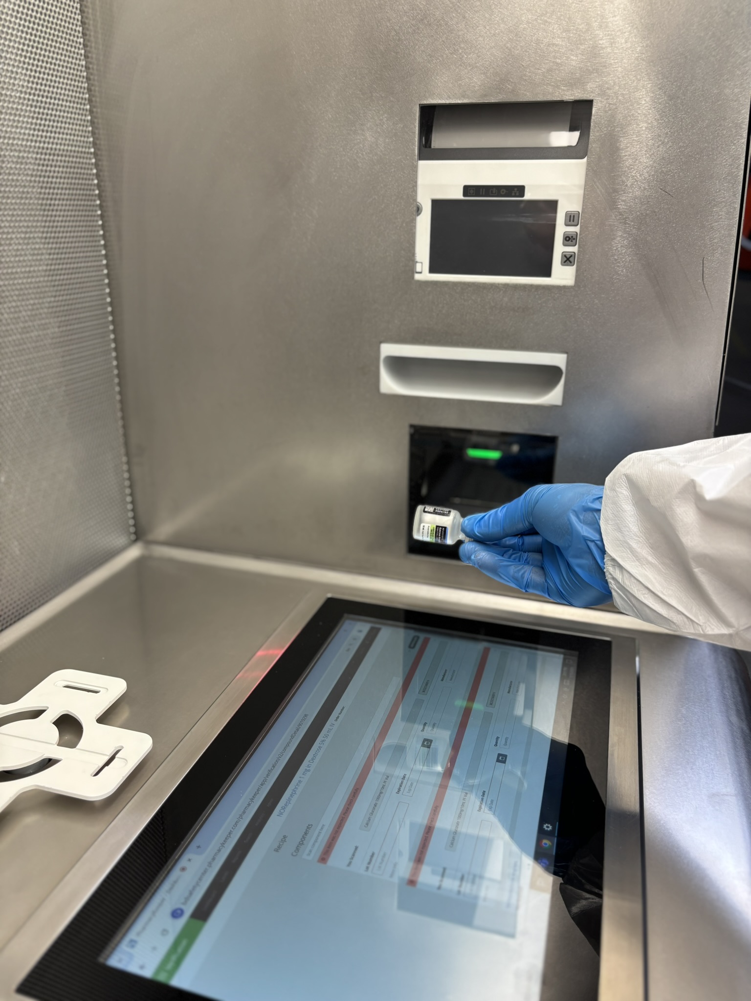 A pharmacist using a Germfree Smarthood™ to scan a vial.