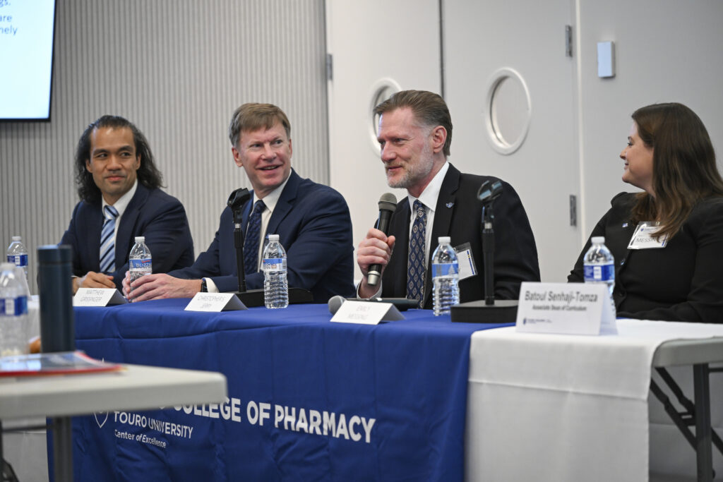 Chris Jerry speaks into a microphone with sitting at a panel with three other industry leaders for their discussion, “Bridging Perspectives: A Comprehensive Approach to Medication Safety Across Hospital, Community Pharmacy, Advocacy, and Regulation.”
