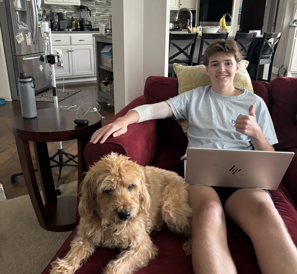 Luke Wachowiak and his dog Tiger while he receives an at-home infusion for an autoimmune condition.