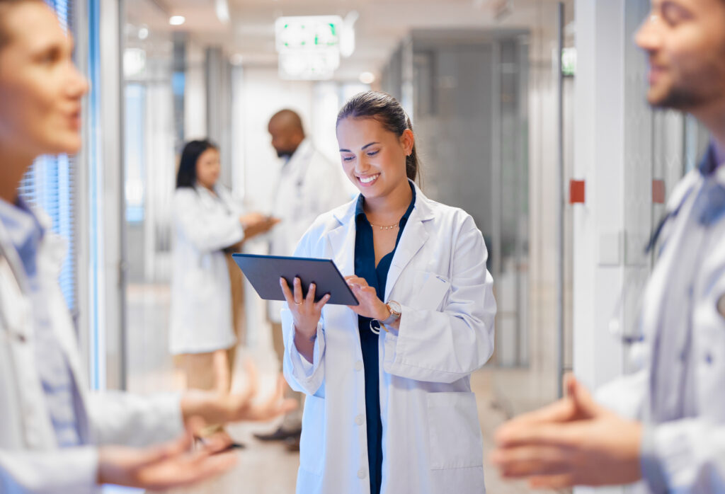 Happy female pharmacist using a tablet and smiling.