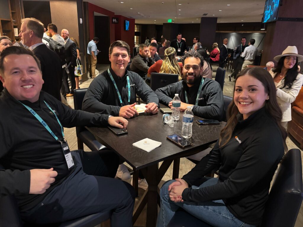 Members of the WeInfuse & RxToolKit team at a table at the Tennr & WeInfuse Happy Hour.