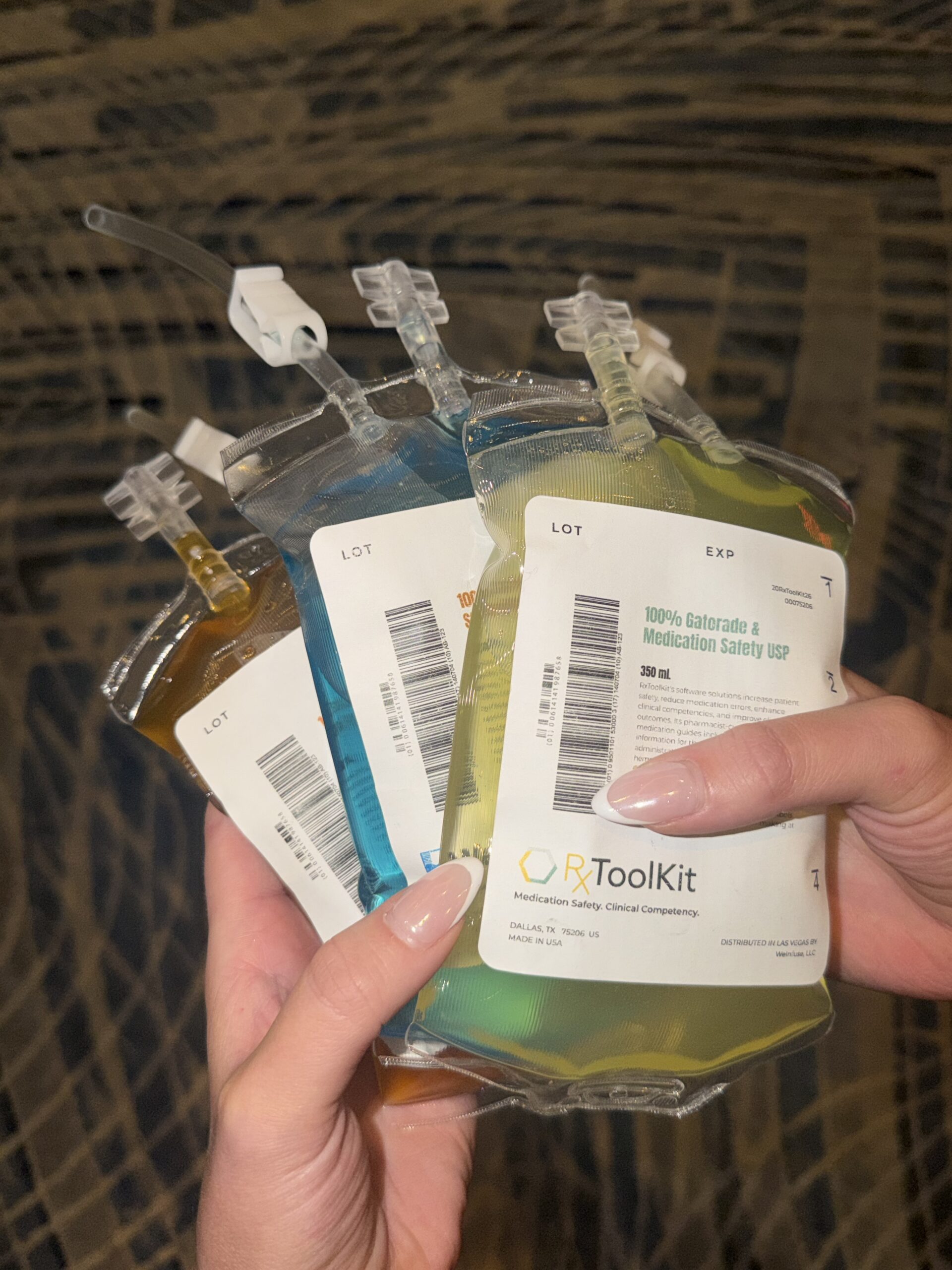 Three IV bags filled with colored gatorade and labelled with information about RxToolKit, WeInfuse, and InfuseTrack.