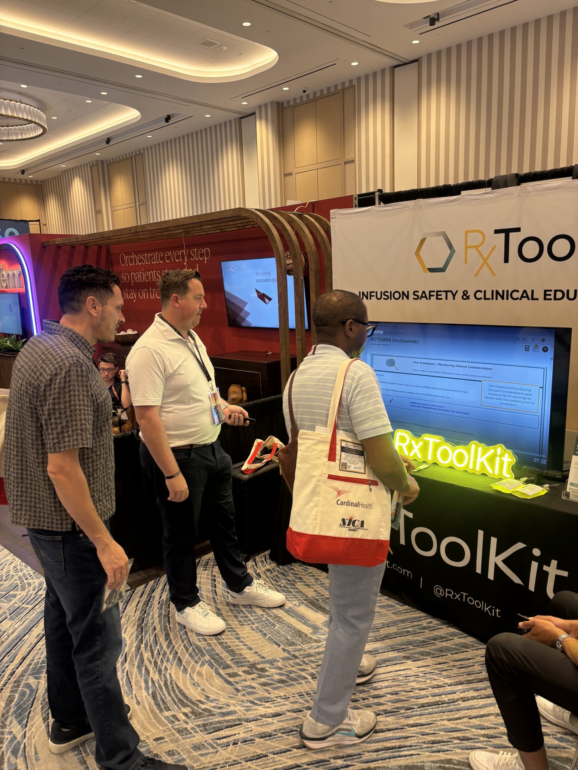 RxToolKit Account Executive Steven Nice speaks with two attendees at the NICA Conference, showing them the RxToolKit software.