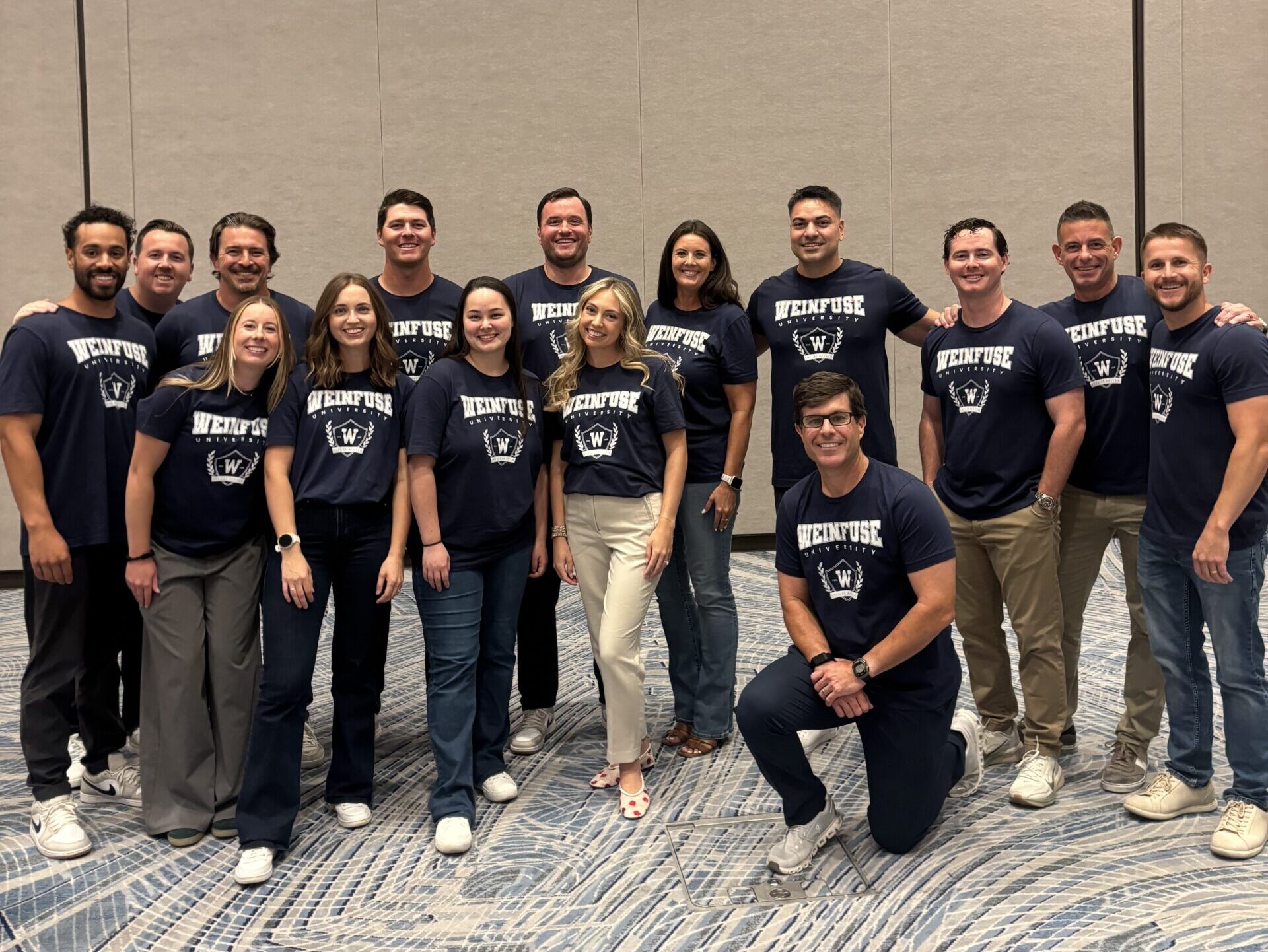The WeInfuse team posing for a photo in matching WeInfuse University t-shirts.