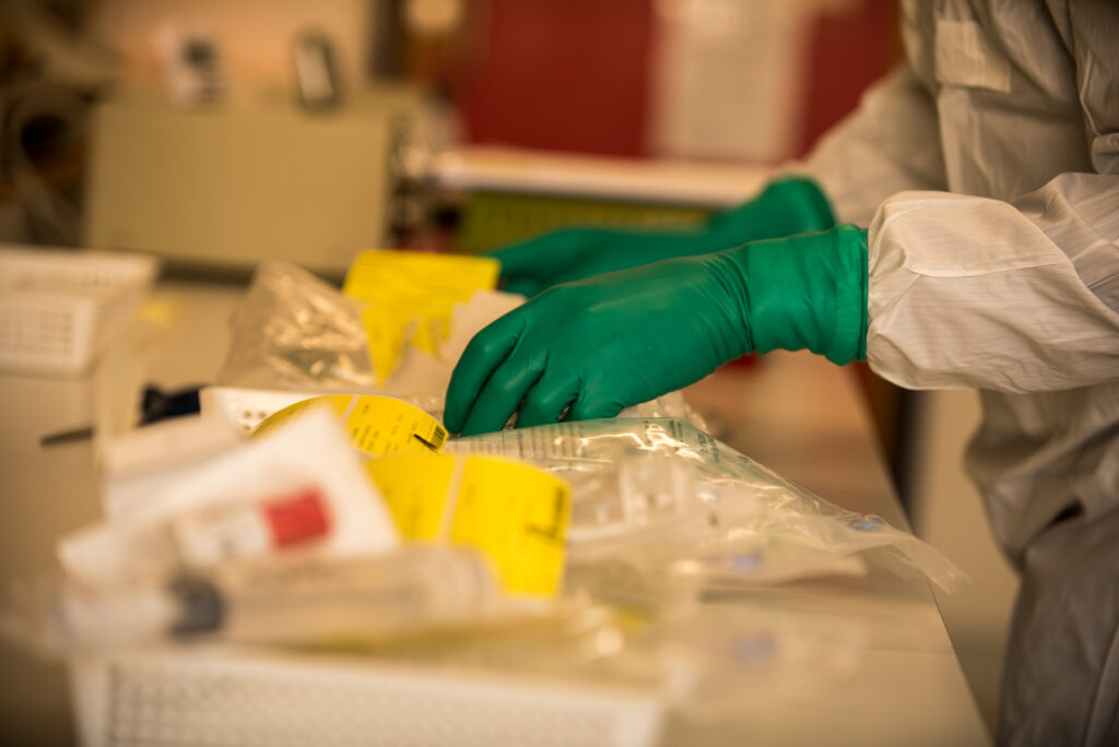 Pharmacy technician checks infusion bags for dispensing at the workstation in the pharmacy's cleanroom.